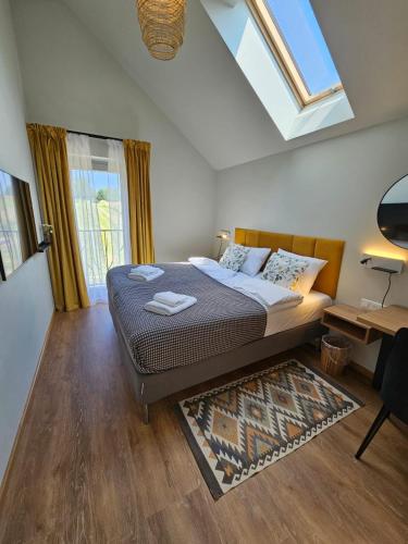 a bedroom with a bed and a skylight at Winnica Tenczyn in Grojec