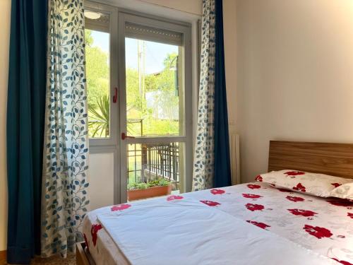 ein Schlafzimmer mit einem Bett und einem Fenster in der Unterkunft Dilman appartamento in Poggiridenti