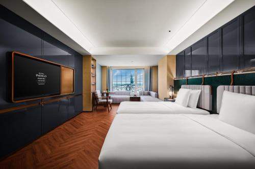 a hotel room with two beds and a flat screen tv at Hotel Indigo Harbin Central Avenue by IHG in Harbin