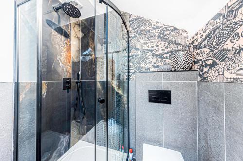 a shower with a glass door in a bathroom at Fairvale House in Northwich