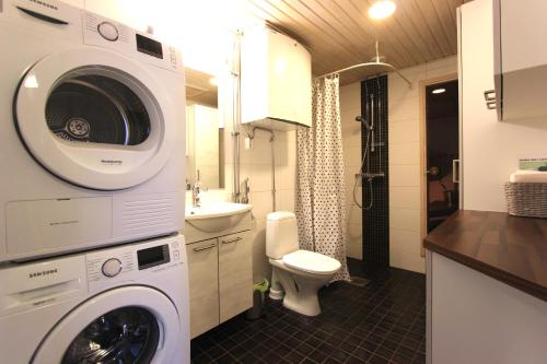 a bathroom with a washing machine and a toilet at Santalux Apartment 2 in Rovaniemi