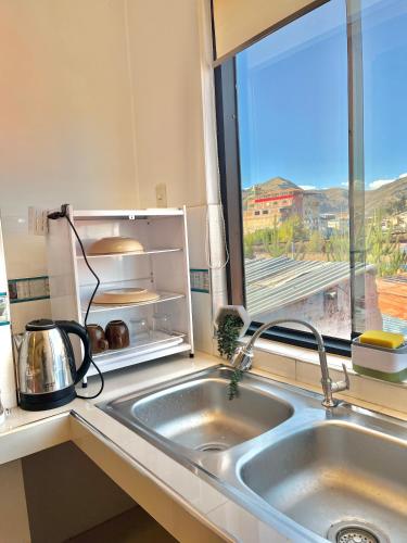 a kitchen with a sink and a window at Alojamiento en SICUANI in Sicuani