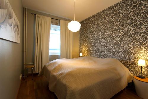 een slaapkamer met een bed en een muur bij Santalux Apartment 2 in Rovaniemi