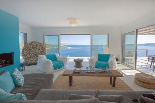 a living room with a couch and a table at Villa Arkoudaki Luxurious Escape with Infinity Pool & Sea Access in Évyiros
