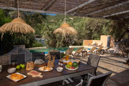 a table with food on it on a patio at Villa Amoudia - Luxury Villa right on the beach with Private Pool in Sivota