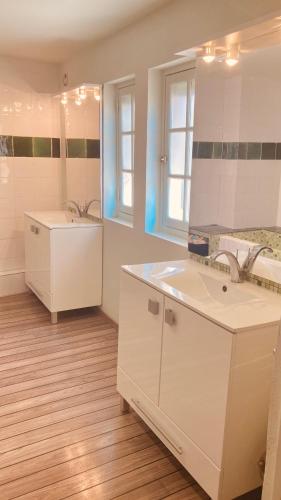 a white bathroom with a sink and a mirror at Le Bel Angle in Arles