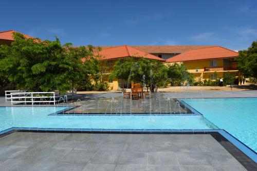 a swimming pool with a fountain in front of a building at Passi Villa in Pasikuda