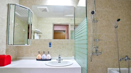 a bathroom with a sink and a shower at Geoje Ocean Hotel in Geoje