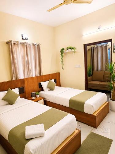a bedroom with two beds and a chair in it at Hotel Ferro in Kumbalgod