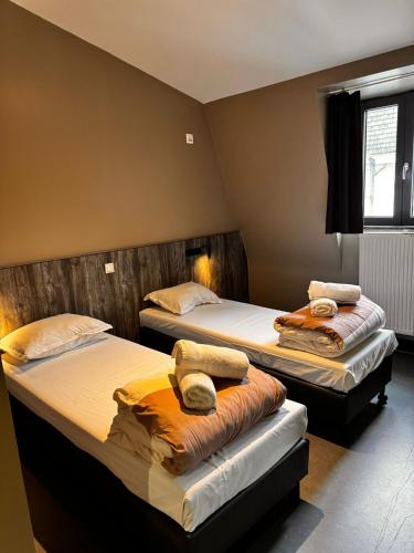 a bedroom with two beds with towels on them at Brxxl 5 City Centre Hostel in Brussels