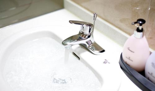 a sink with a faucet in a bathroom at Geoje Ocean Hotel in Geoje 