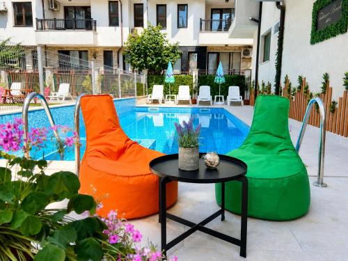 two chairs and a table next to a pool at Tabanov Beach Hotel in Sozopol