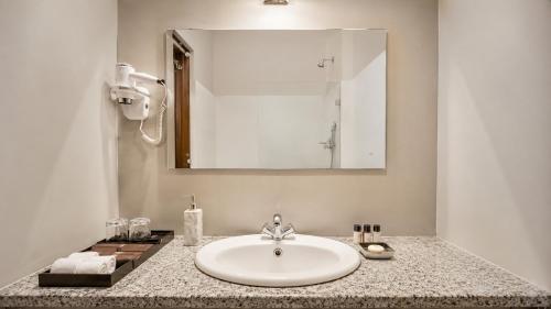 a bathroom counter with a sink and a mirror at Mount Himalayan Hotel in Gangtok