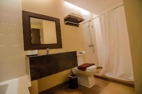 a bathroom with a toilet and a sink and a mirror at Apple Tree Resort & Hotel in Opol