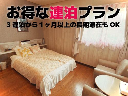 a bedroom with a bed and a table and a chair at Hotel Vegas (Adult Only) in Sapporo