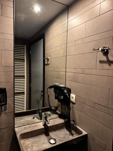 a bathroom with a sink and a mirror at Brxxl 5 City Centre Hostel in Brussels