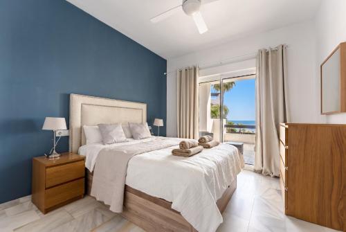 a bedroom with a large bed with a blue wall at 203 Arruzafa Sea View in Málaga