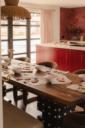 a wooden table with bowls and plates on it in a kitchen at Gorgeous Stylish Home Near Longleat and Bath with Private Heated Pool and Sauna in Corsley