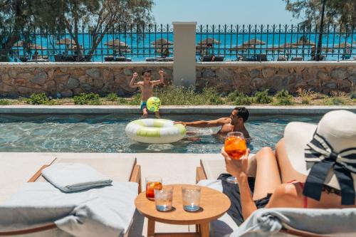 a group of people playing in the pool at a resort at Santo Miramare Beach Resort in Perivolos