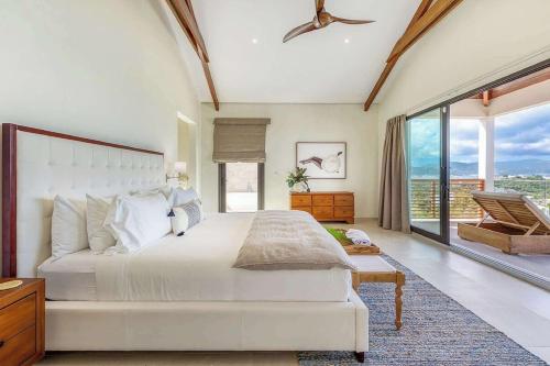 a bedroom with a white bed and a large window at Villa with exclusive views in Marigot