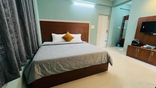 a bedroom with a large bed and a television at Fabhotel Aman palace in Mumbai