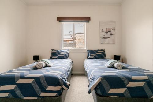 two twin beds in a room with a window at Joshi's Villa in Seymour