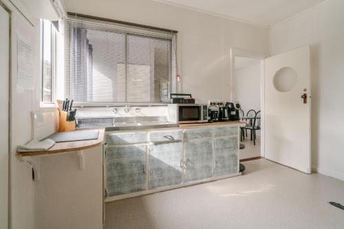a kitchen with a sink and a microwave on a counter at Joshi's Villa in Seymour