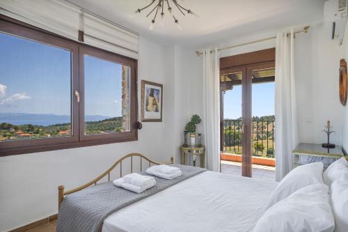 a bedroom with a bed and a large window at Halkidiki Sunhouse in Paliouri