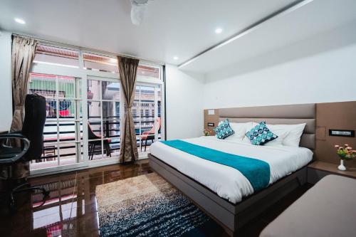 a bedroom with a bed and a large window at Anaya Regency in Naya Bāzār