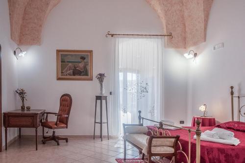 1 dormitorio con cama, escritorio y silla en B&b Donna Concetta, en Felline