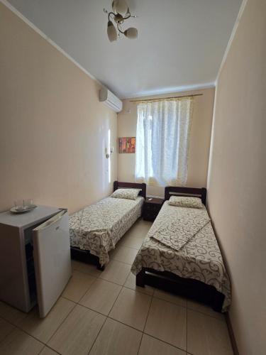 a small room with two beds and a window at ОлександріЯ in Odesa