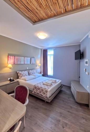 a bedroom with a bed and a couch and a table at Melina Hotel - Central in Polygryos