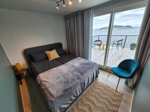 a bedroom with a bed and a large window at Villa with a view in Ålesund
