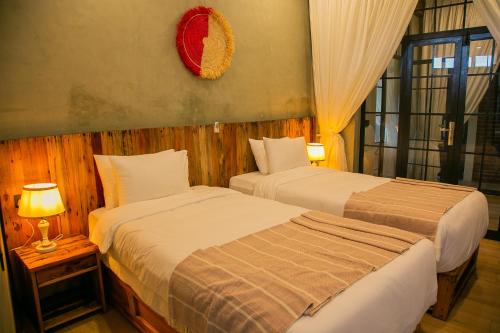 two beds in a hotel room with a window at Zondela House in Nkoanrua