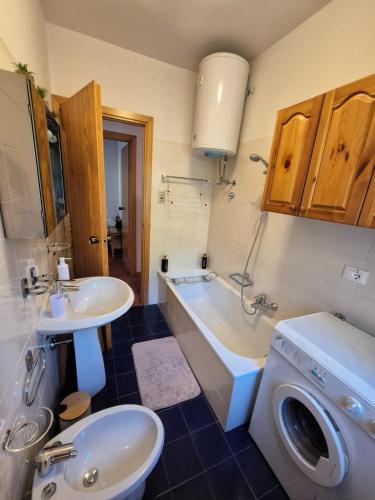 a bathroom with a sink and a washing machine at Il Posticino del Lago di Como in Esino Lario