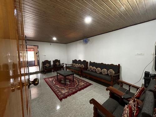 a living room with couches and a table at Kds Homestay in Gonikoppal