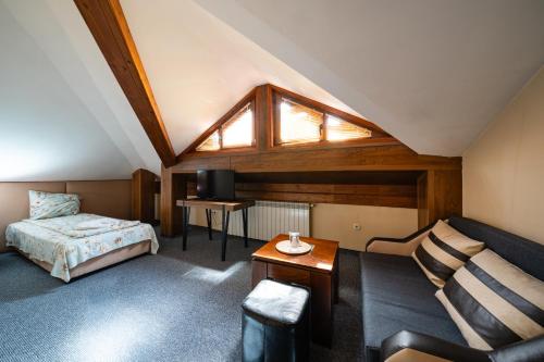 a hotel room with a bed and a couch at Kap House Family Hotel in Bansko