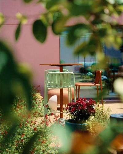 a table and a chair and a table and flowers at Hotels 705 O'Porto Hotel in Porto