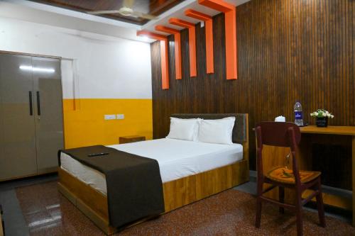 a bedroom with a bed and a desk and a chair at Ocean Queen Palace Kovalam in Trivandrum