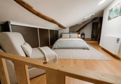 a large bedroom with a bed and a chair at Ribeirinha Guesthouse in Guarda