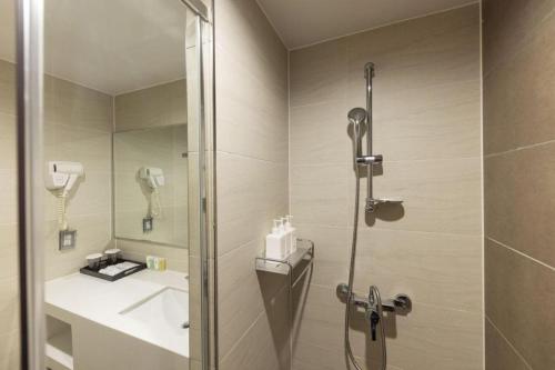 a bathroom with a shower and a sink at Saipan World Resort in Susupe