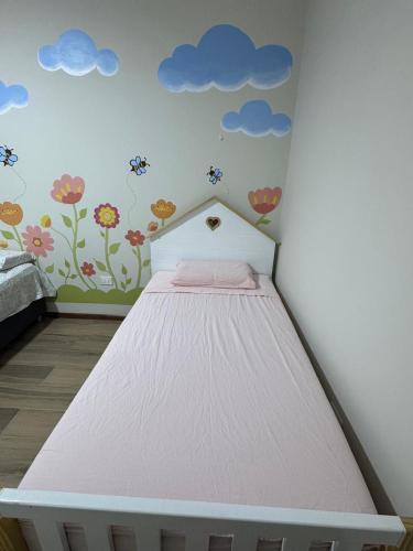 a bedroom with a bed with flowers and clouds on the wall at Casa Almara - Ica in Ica