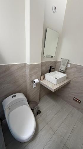 a bathroom with a white toilet and a sink at Casa Almara - Ica in Ica