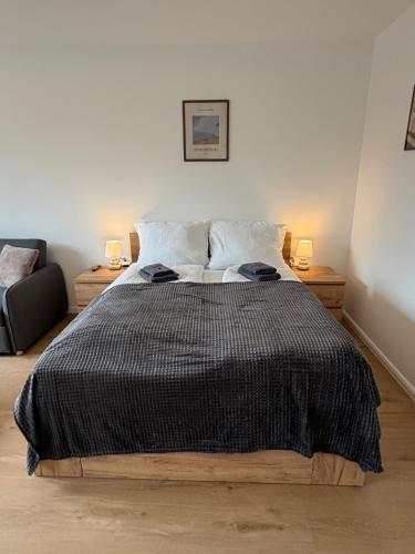 a bedroom with a bed with a black comforter at Wohnglück Leer City Nr 3 in Leer