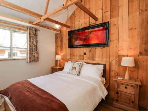 a bedroom with a bed and a tv on the wall at Little Orchard in Swallowcliffe