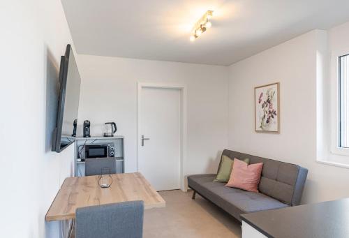 a living room with a couch and a table at Bluemlisalp Studio - Aare Jungfrau AG in Spiez