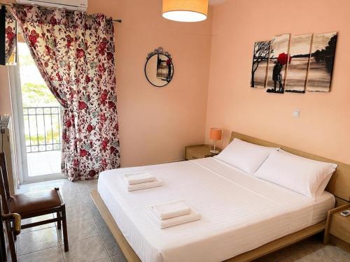 a bedroom with a white bed with a window at Villa Theodora 30m from the beach in Egira