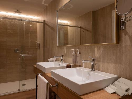 a bathroom with two sinks and a shower at Mövenpick Hotel Bari in Bari