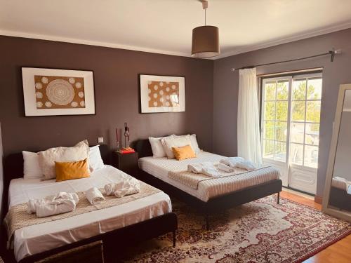 a bedroom with two beds and a window at The Yellow Retreat in A dos Cunhados