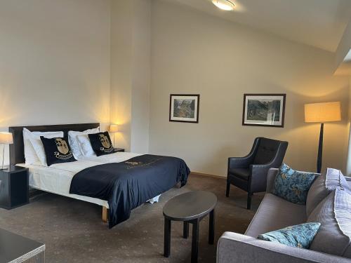 a hotel room with a bed and a couch at Grand Hotel Skei - Unike Hoteller in Skei